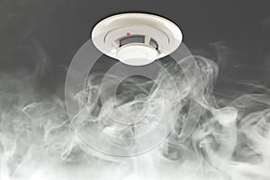 Smoke detector on ceiling, fire alarm in action photo