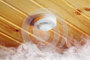 Smoke detector in wooden house, fire alarm in action