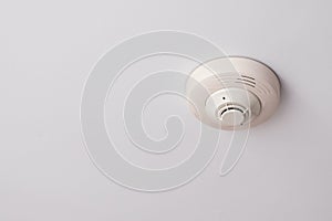 Smoke detectors are mounted on a white ceiling.