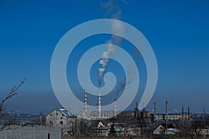 Smoke and ecology. Pipes of thermal power plants against a blue sky. A stream of black smoke comes out of the pipes