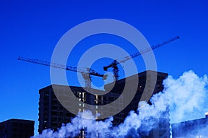 Smoke Engulfs Urban Skyline, construction cranes at night, construction site