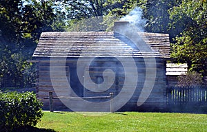 Smoke exits chimney of pioneer cabin photo
