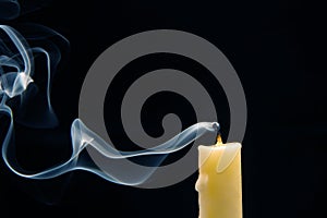 Smoke from an extinguished candle on a dark background. The concept of spirituality and the end of life