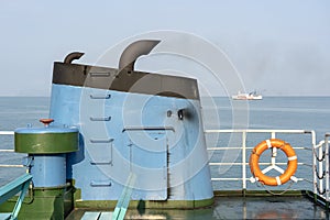 Smoke from ferry boat flue during sea with sunlight, sea water and clear sky in background, Thailand