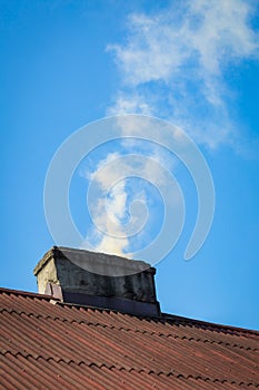 Smoke flying over chimney of countryside house