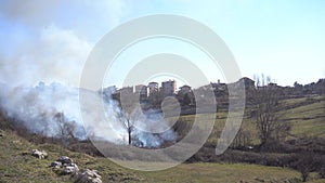 Smoke from forest fires in the mountains rises to buildings in the city