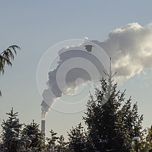 Smoke from industrial chimneys against the blue sky. Pollution