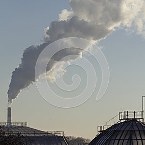 Smoke from industrial chimneys against the blue sky. Pollution