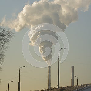 Smoke from industrial chimneys against the blue sky. Pollution