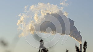 Smoke from industrial chimneys against the blue sky. Pollution