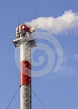 Smoke from industrial chimneys against the blue sky. Pollution