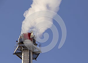 Smoke from industrial chimneys against the blue sky. Pollution