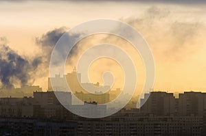 Smoke from industrial chimneys at dawn city.