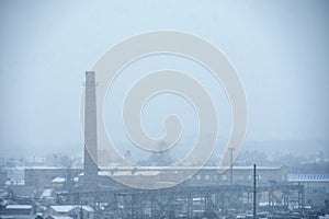 Smoke from a large pipe in an old factory pollutes the air in the winter