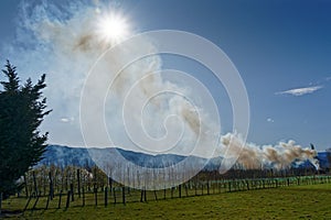 Smoke from an orchard prunings burn off bonfire billowing into the air