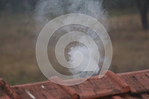 Smoke os exiting the chimney from an ancient oven on india. Ancient times people were using hard fuel for cooking