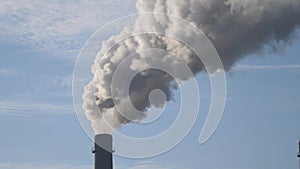 Smoke from a pipe on a background of blue sky photo