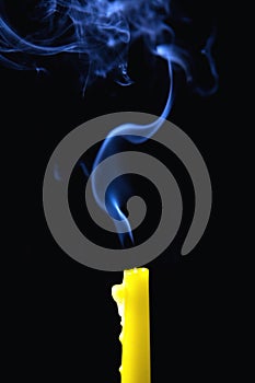The smoke rises above the extinguished candle.