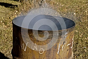 Smoke rises from old burn barrel photo