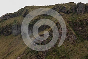 Smoke rises from a volcanic flue in the Batur Crater. Geological formation in active volcano with volcanic chimney.