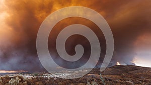 Smoke from Sand brush fire covering Santa Clarita cityscape at sunset in California