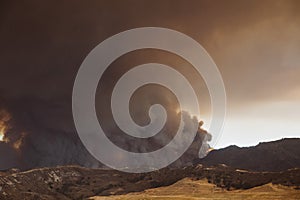 Smoke from Sand brush fire covering Santa Clarita cityscape at sunset in California