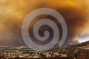 Smoke from Sand brush fire covering Santa Clarita cityscape at sunset in California