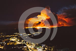 Smoke from Sand brush fire covering Santa Clarita cityscape at sunset in California