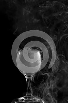 Smoke shisha in cocktail glass on a black background.