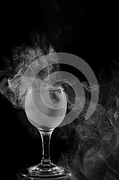 Smoke shisha in cocktail glass on a black background.