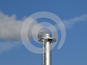 Smoke spews out of a chimney at an industrial plant
