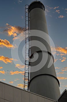 Smoke stack near the river front of historic Savanah Georgia. Evening sunset clouds with beautiful warm glow.