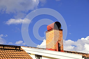 Smoke stack on the tiled roof of a family house