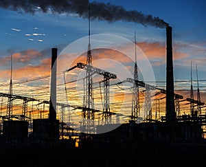 Smoke stacks at coal burning power plant, industrial silhouette.