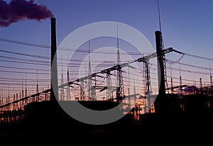 Smoke stacks at coal burning power plant, industrial silhouette.