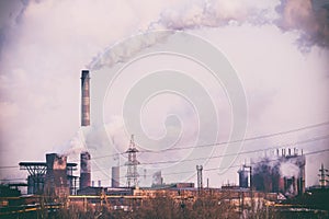 Smoke stacks in a working factory emitting steam, smog and air p