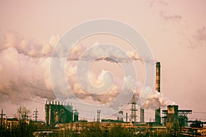 Smoke stacks in a working factory emitting steam, smog and air p