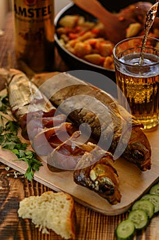 Smoked Baikal Omul on the wooden table whith a glass of beer. Rustic style, organic food.