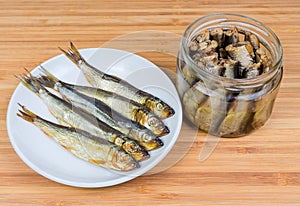 Smoked baltic herring on saucer and preserved in oil