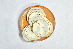 smoked cheese slice in orange plate isolated