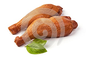 Smoked chicken legs with basil leaves, isolated on white background