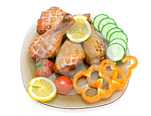 smoked chicken legs with vegetables and lemon on white background