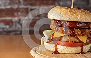 smoked chickenburger centred on wooden plate close up photo