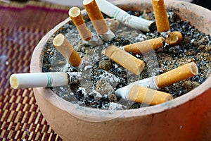 Smoked cigarettes in a dirty ashtray