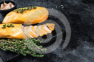 Smoked cut chicken breast fillet meat delicacy. Black background. Top view. Copy space