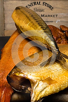 Smoked fish, mackerel, sig, perch and cod roe on the black wooden table