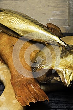 Smoked fish, mackerel, sig, perch and cod roe on the black wooden table. Omega 3 source. Polyunsaturated fats