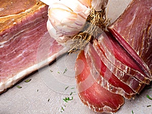 Smoked ham, jerky corned beef on table with garlic, herbs