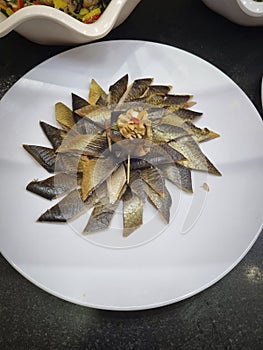 Smoked herring slices on a white plate in a restaurant