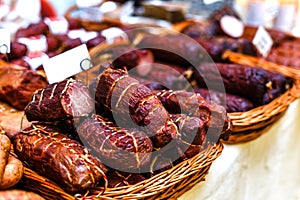 Smoked meat and sausages in wicker baskets sold on the market